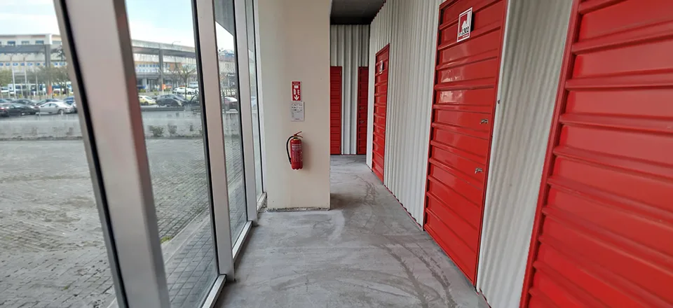 Troy Depo tesisinde kepenkli depo birimlerinin bulunduğu havalandırmalı koridor — iklim kontrollü depolama alanı